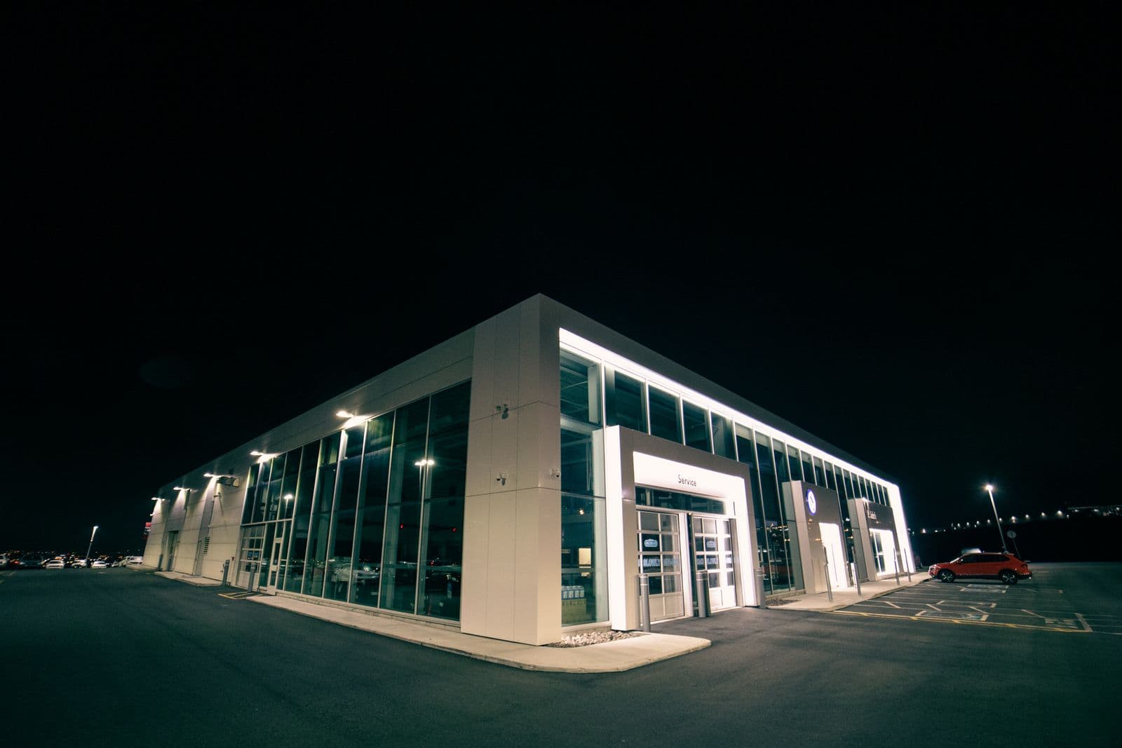 Modern car dealership showroom exterior at night